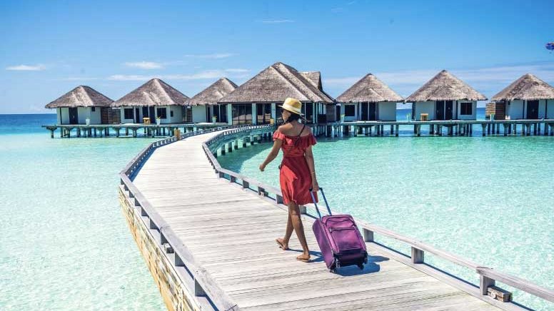 Woman travel to island huts with luggage